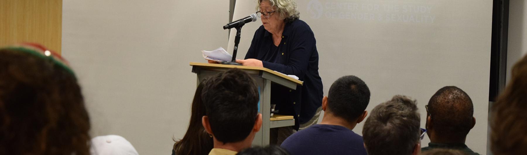 People seated listening to a speaker.