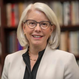 Portrait of woman in glasses and suit jacket (Amanda Woodward)